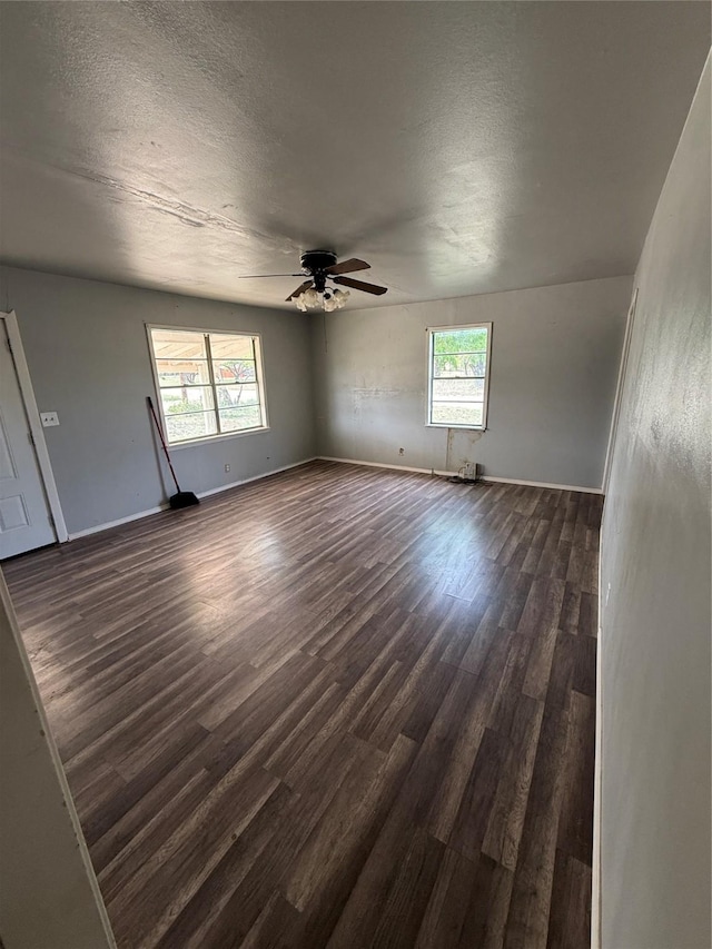 701 Perry, Santa Anna, TX 76878 - empty room with dark wood-type flooring, ceiling fan, a textured ceiling, and baseboards