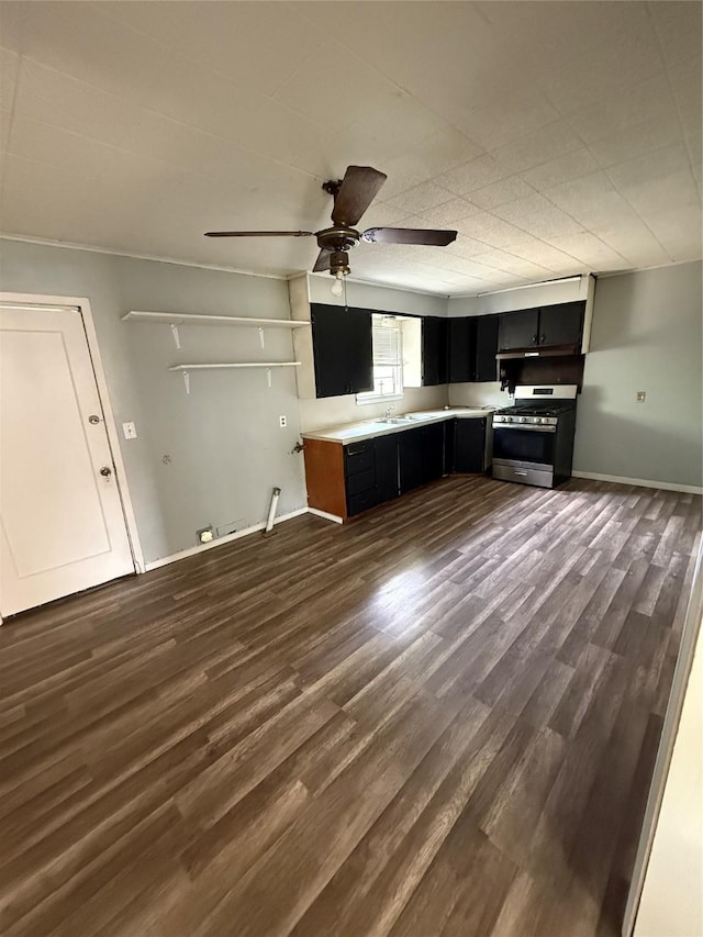 701 Perry, Santa Anna, TX 76878 - kitchen with gas stove, dark cabinets, a ceiling fan, light countertops, and a sink