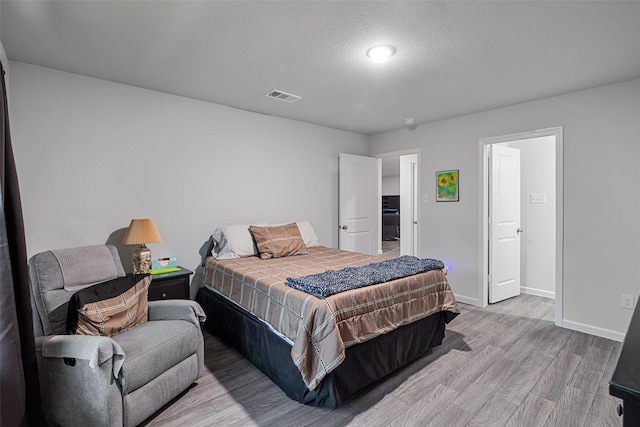 111 Peace Lily Way, Tolar, TX 76476 - bedroom with light wood finished floors, baseboards, and a textured ceiling