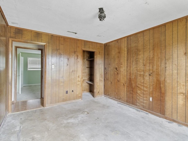 110 Twin Cir, Wortham, TX 76693 - unfurnished bedroom featuring unfinished concrete floors and wooden walls