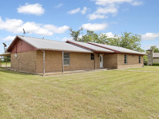 110 Twin Cir, Wortham, TX 76693 - back of property with a lawn, metal roof, and brick siding