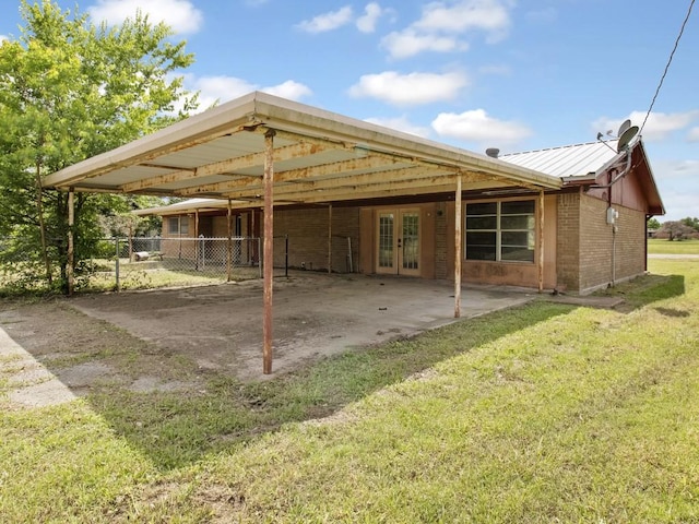 110 Twin Cir, Wortham, TX 76693 - back of house featuring french doors, a carport, and brick siding