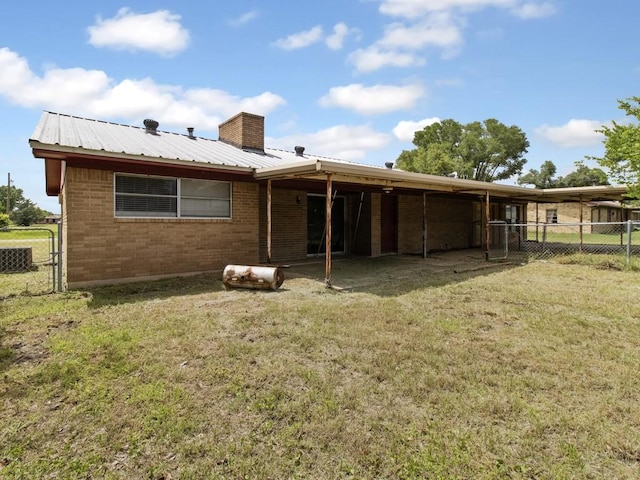 110 Twin Cir, Wortham, TX 76693 - rear view of house with brick siding, metal roof, and a chimney