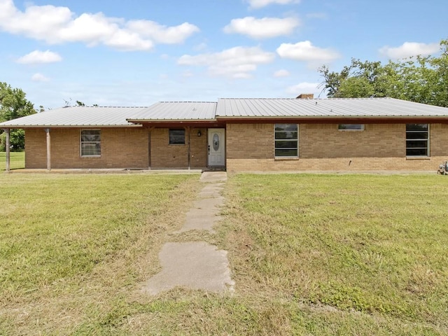 110 Twin Cir, Wortham, TX 76693 - view of front of home with a front yard, metal roof, and brick siding