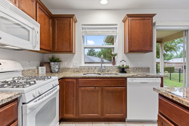 7735 Whirlwind Dr, Frisco, TX 75036 - kitchen with white appliances, a sink, light stone countertops, and brown cabinets