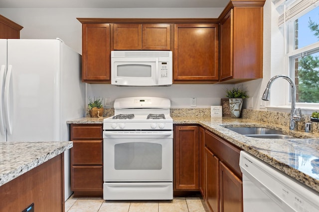 7735 Whirlwind Dr, Frisco, TX 75036 - kitchen with white appliances, a sink, brown cabinetry, and light stone counters