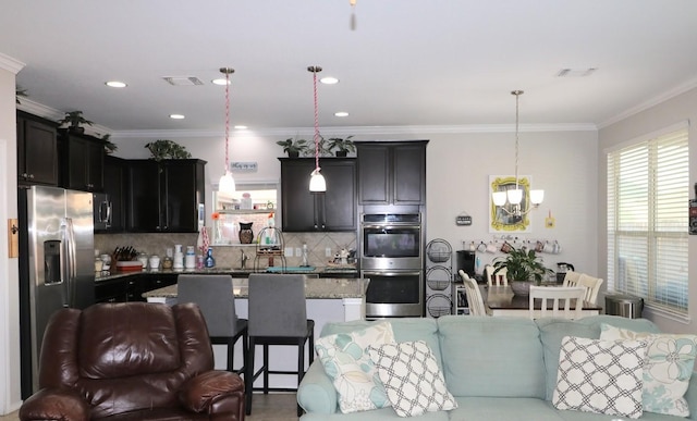 5516 Tama Dr, Waco, TX 76708 - kitchen featuring stainless steel appliances, a chandelier, open floor plan, tasteful backsplash, and ornamental molding