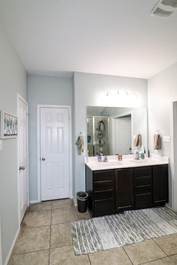 5516 Tama Dr, Waco, TX 76708 - full bathroom featuring a stall shower, tile patterned floors, and double vanity