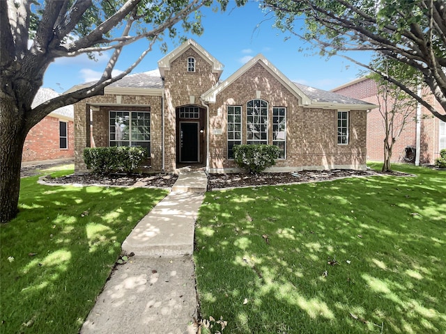 11473 Las Polamas Dr, Frisco, TX 75033 - view of front of house featuring a front lawn, brick siding, and a shingled roof