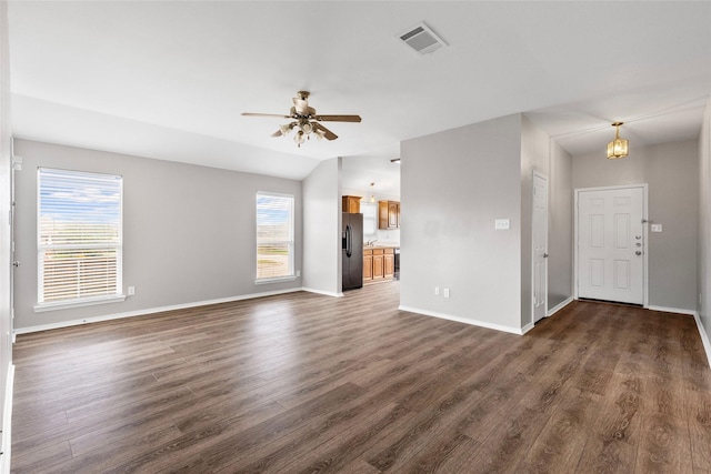 1502 Jacksons Run, Greenville, TX 75402 - unfurnished living room with dark wood-style flooring, baseboards, ceiling fan, and a chandelier