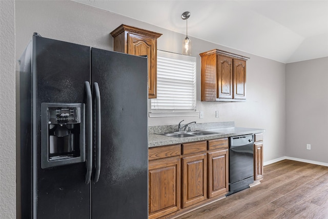 1502 Jacksons Run, Greenville, TX 75402 - kitchen featuring black appliances, light wood-style floors, a sink, brown cabinetry, and vaulted ceiling