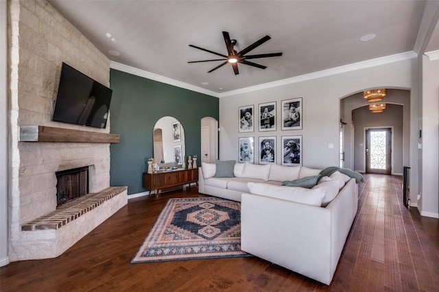 13400 Summer Moon Trl, Ponder, TX 76259 - living room featuring arched walkways, a ceiling fan, wood finished floors, crown molding, and a stone fireplace