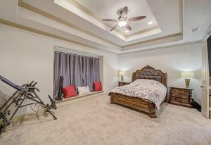 2575 Wincrest Dr, Rockwall, TX 75032 - bedroom featuring a tray ceiling, crown molding, carpet, and ceiling fan