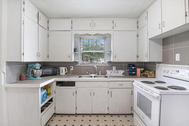 116 S Barron St, Arp, TX 75750 - kitchen featuring white range with electric stovetop, a sink, black microwave, light countertops, and backsplash
