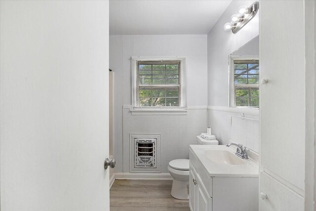 116 S Barron St, Arp, TX 75750 - bathroom featuring heating unit, vanity, healthy amount of natural light, toilet, and tile walls