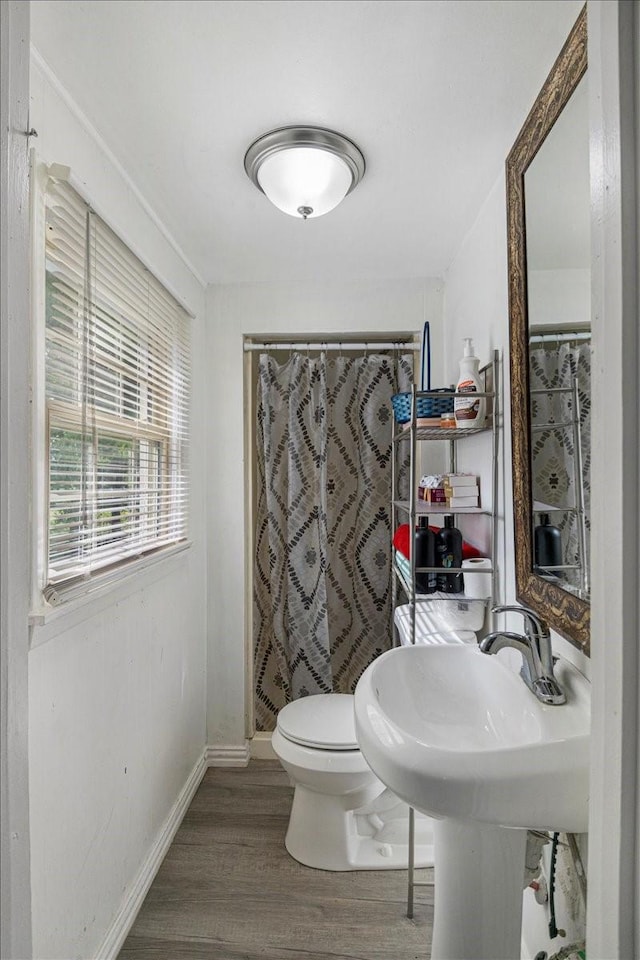 116 S Barron St, Arp, TX 75750 - full bath with wood finished floors, baseboards, toilet, and a shower with curtain