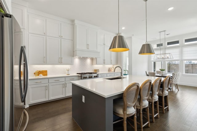 3411 Torrance Blvd, Frisco, TX 75034 - kitchen with stainless steel appliances, a sink, dark wood-type flooring, light countertops, and tasteful backsplash