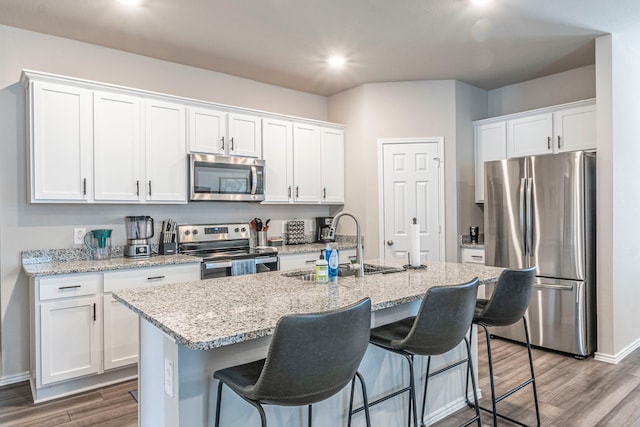 2358 Aylesbury Dr, Copperas Cove, TX 76522 - kitchen featuring stainless steel appliances, white cabinetry, a sink, wood finished floors, and a kitchen island with sink
