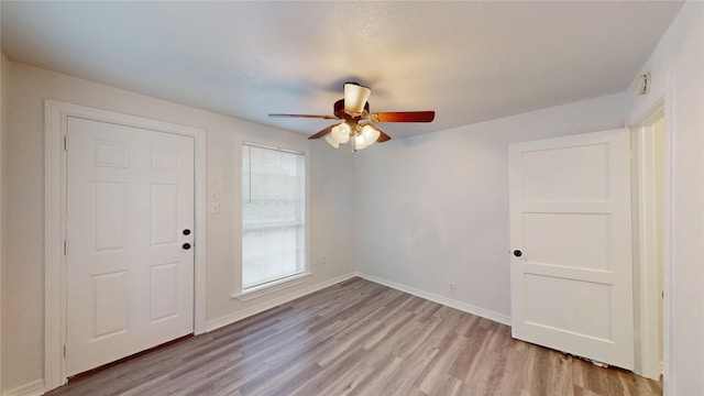 1107 Vine St, Weatherford, TX 76086 - empty room with light wood-style floors, ceiling fan, and baseboards