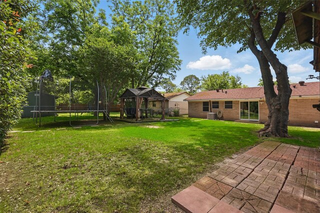 2433 Loyce Dr, Mesquite, TX 75149 - view of yard featuring a trampoline, a gazebo, central AC unit, and a patio area