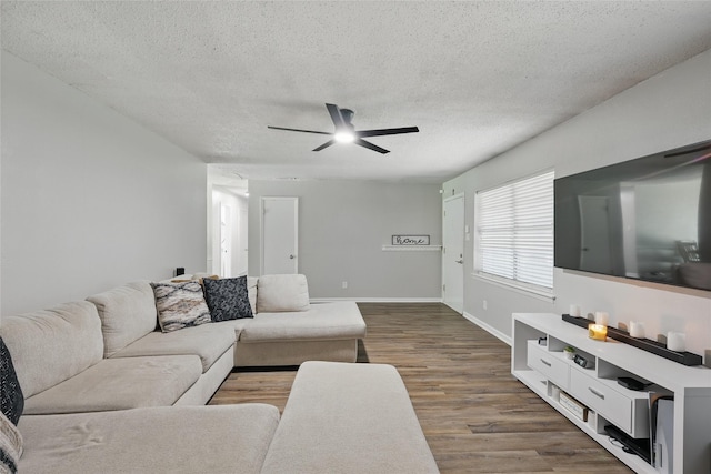 2433 Loyce Dr, Mesquite, TX 75149 - living room featuring a textured ceiling, ceiling fan, dark wood-style floors, and baseboards