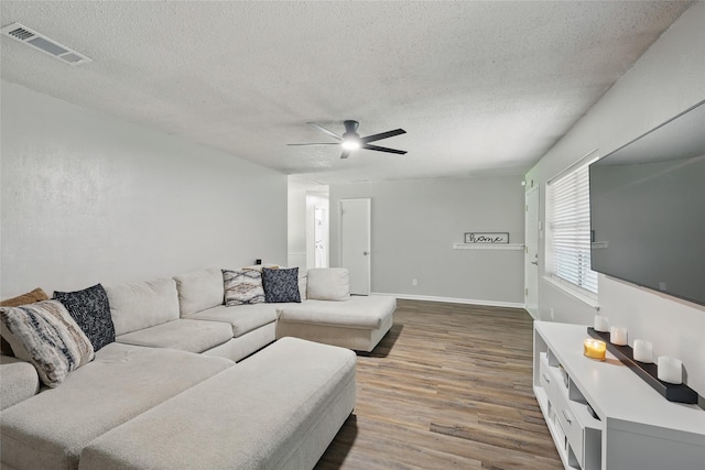 2433 Loyce Dr, Mesquite, TX 75149 - living room featuring wood finished floors, a textured ceiling, ceiling fan, and baseboards
