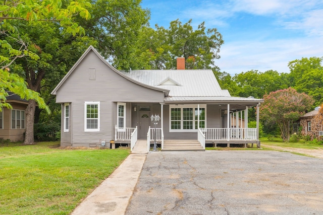 1315 E Pecan St, Gainesville, TX 76240 - view of front of property with a chimney, covered porch, a front yard, and metal roof