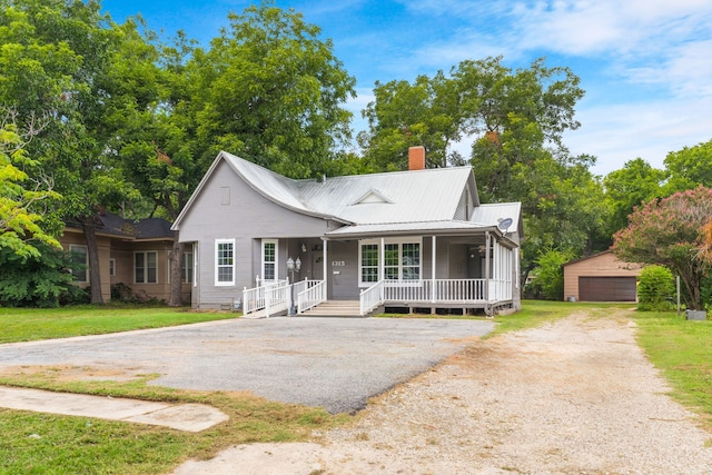 1315 E Pecan St, Gainesville, TX 76240 - view of front of home with covered porch, a chimney, an outbuilding, metal roof, and a detached garage