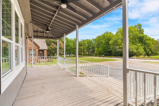 1315 E Pecan St, Gainesville, TX 76240 - wooden deck with a ceiling fan, covered porch, and view of wooded area