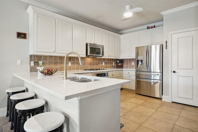 6008 Thistle Way, Denton, TX 76210 - kitchen featuring stainless steel appliances, a sink, crown molding, a peninsula, and light countertops