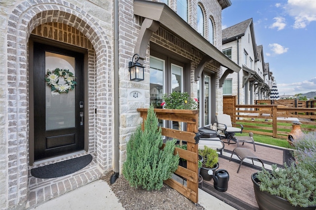 424 Somerville Dr, Mckinney, TX 75071 - view of exterior entry with fence, stone siding, and brick siding