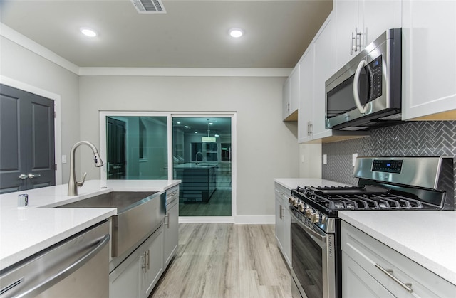 3325 Norris St, Plano, TX 75074 - kitchen featuring appliances with stainless steel finishes, a sink, light wood-type flooring, light countertops, and recessed lighting