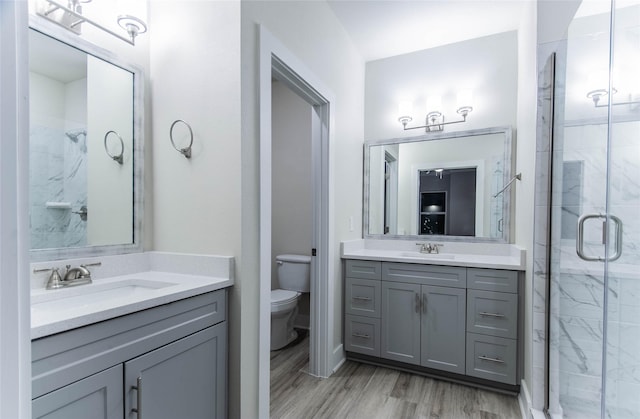 3325 Norris St, Plano, TX 75074 - bathroom featuring a shower stall, toilet, wood finished floors, and two vanities