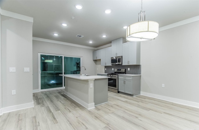 3325 Norris St, Plano, TX 75074 - kitchen featuring stainless steel appliances, light wood-style flooring, ornamental molding, light countertops, and a center island with sink