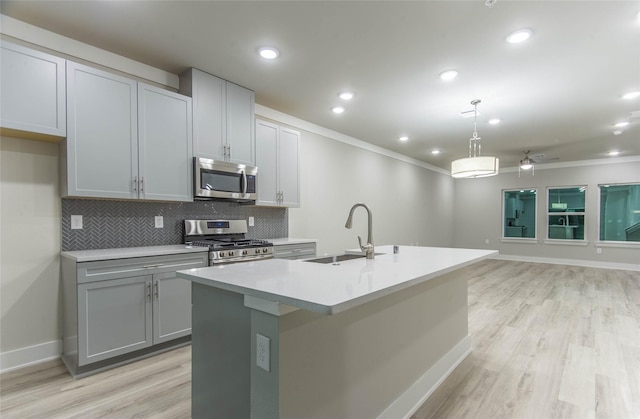 3325 Norris St, Plano, TX 75074 - kitchen with stainless steel appliances, a sink, a center island with sink, tasteful backsplash, and light wood-style floors