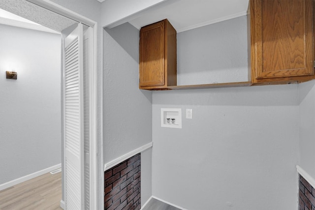 3355 La Mesa Dr, Weatherford, TX 76085 - washroom with cabinet space, light wood-style floors, washer hookup, and baseboards