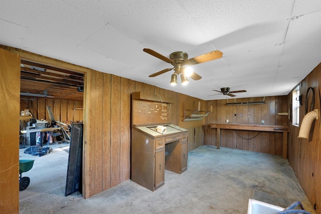 3355 La Mesa Dr, Weatherford, TX 76085 - kitchen featuring wood walls, brown cabinetry, ceiling fan, and concrete floors