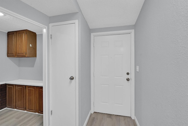 3355 La Mesa Dr, Weatherford, TX 76085 - entryway with light wood-type flooring, a textured ceiling, and baseboards