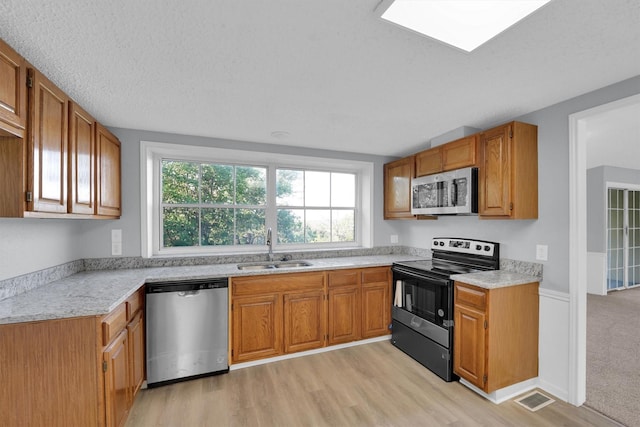 3355 La Mesa Dr, Weatherford, TX 76085 - kitchen with appliances with stainless steel finishes, a sink, light countertops, and light wood-style floors
