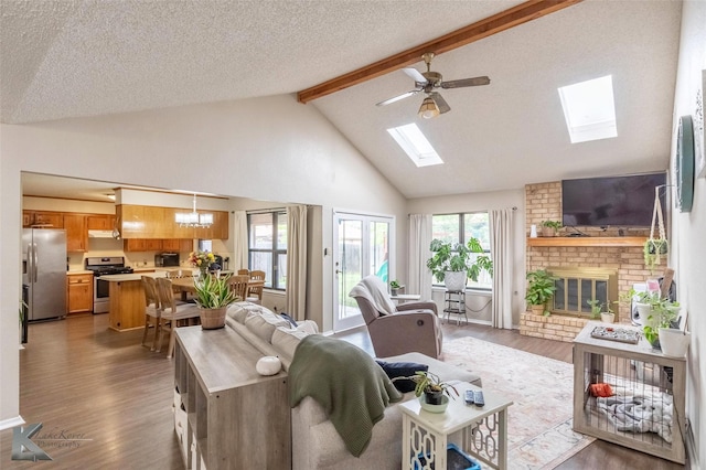 3526 Carnation Ct, Abilene, TX 79606 - living room with a skylight, beam ceiling, a brick fireplace, wood finished floors, and healthy amount of natural light
