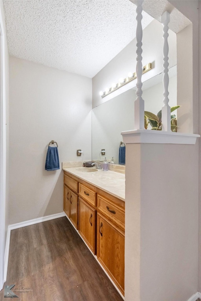 3526 Carnation Ct, Abilene, TX 79606 - bathroom with wood finished floors, a textured ceiling, vanity, and baseboards