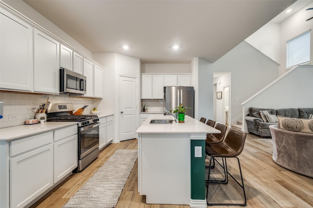1252 Milfoil Dr, Justin, TX 76247 - kitchen with stainless steel appliances, open floor plan, a sink, decorative backsplash, and a breakfast bar area