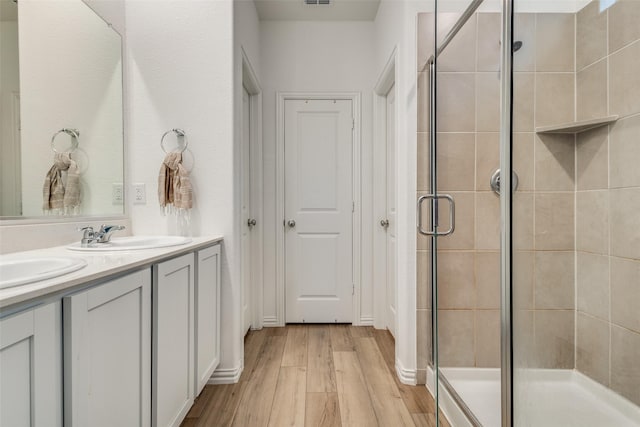 1252 Milfoil Dr, Justin, TX 76247 - bathroom featuring wood finished floors, a stall shower, and double vanity