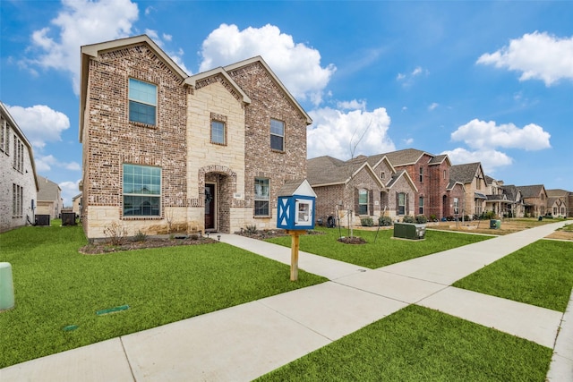 1252 Milfoil Dr, Justin, TX 76247 - view of front of house featuring a front lawn, brick siding, a residential view, central AC, and stone siding