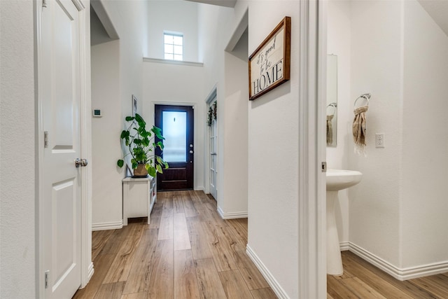 1252 Milfoil Dr, Justin, TX 76247 - entryway featuring light wood-type flooring, arched walkways, and baseboards