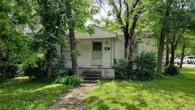 bungalow-style home featuring a front lawn and covered porch