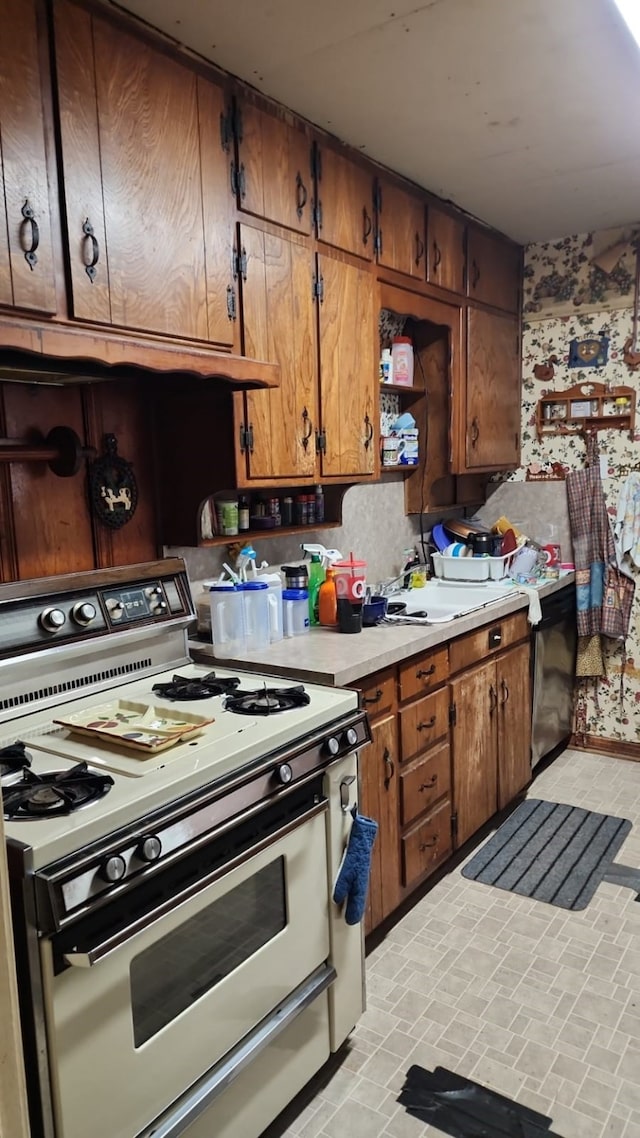 kitchen with white range with gas stovetop, brick patterned flooring, light countertops, open shelves, and brown cabinetry