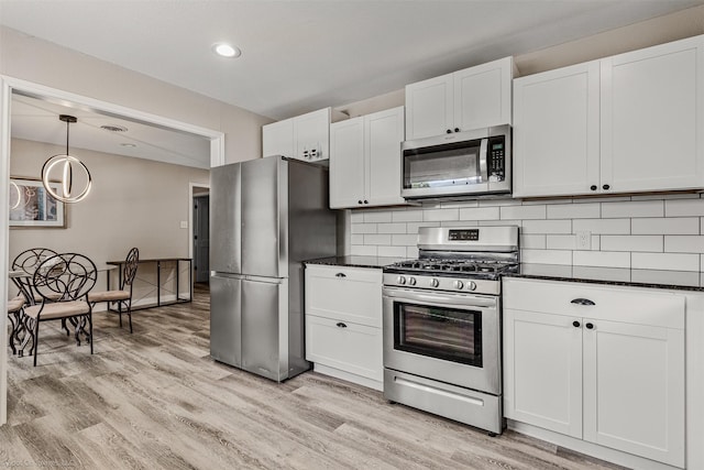 1701 W College St, Sherman, TX 75092 - kitchen with appliances with stainless steel finishes, light wood-style floors, white cabinets, decorative backsplash, and recessed lighting