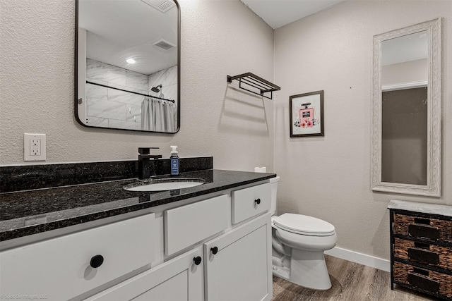 1701 W College St, Sherman, TX 75092 - bathroom featuring wood finished floors, vanity, toilet, and baseboards