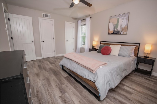 1701 W College St, Sherman, TX 75092 - bedroom with wood finished floors, baseboards, ceiling fan, and two closets